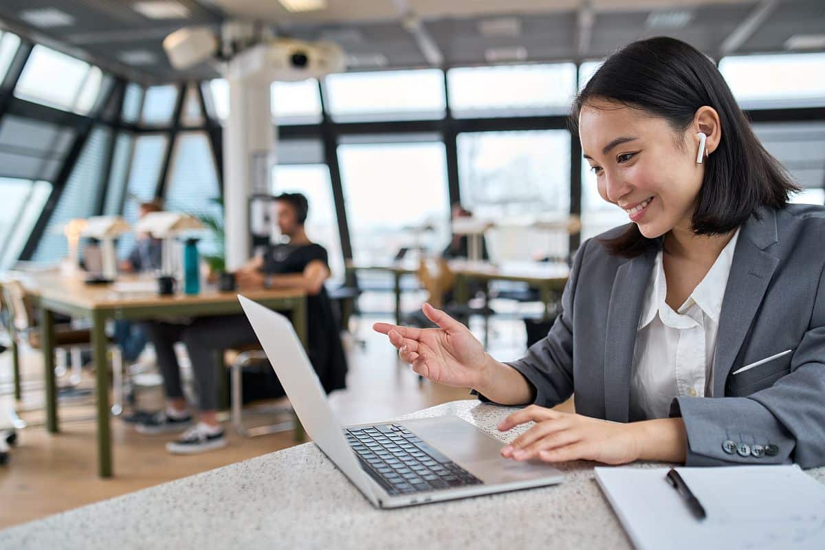 Smiling business professional in conversation on her laptop; better total reward packages concept