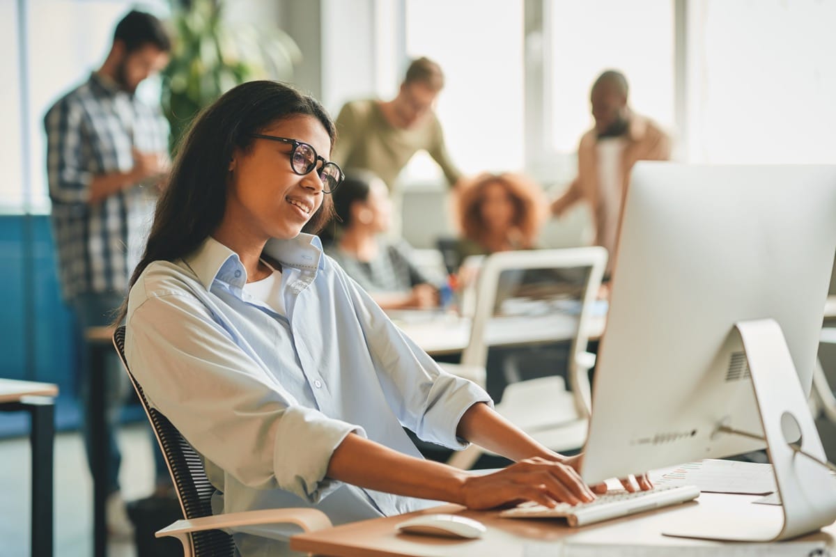 Office worker using computer at desk; on-demand pay concept