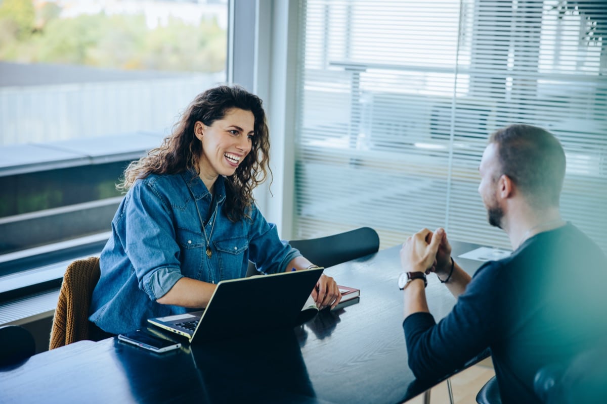 Smiling businesswoman taking interview of a job applicant; Recruitment and Total Reward concept