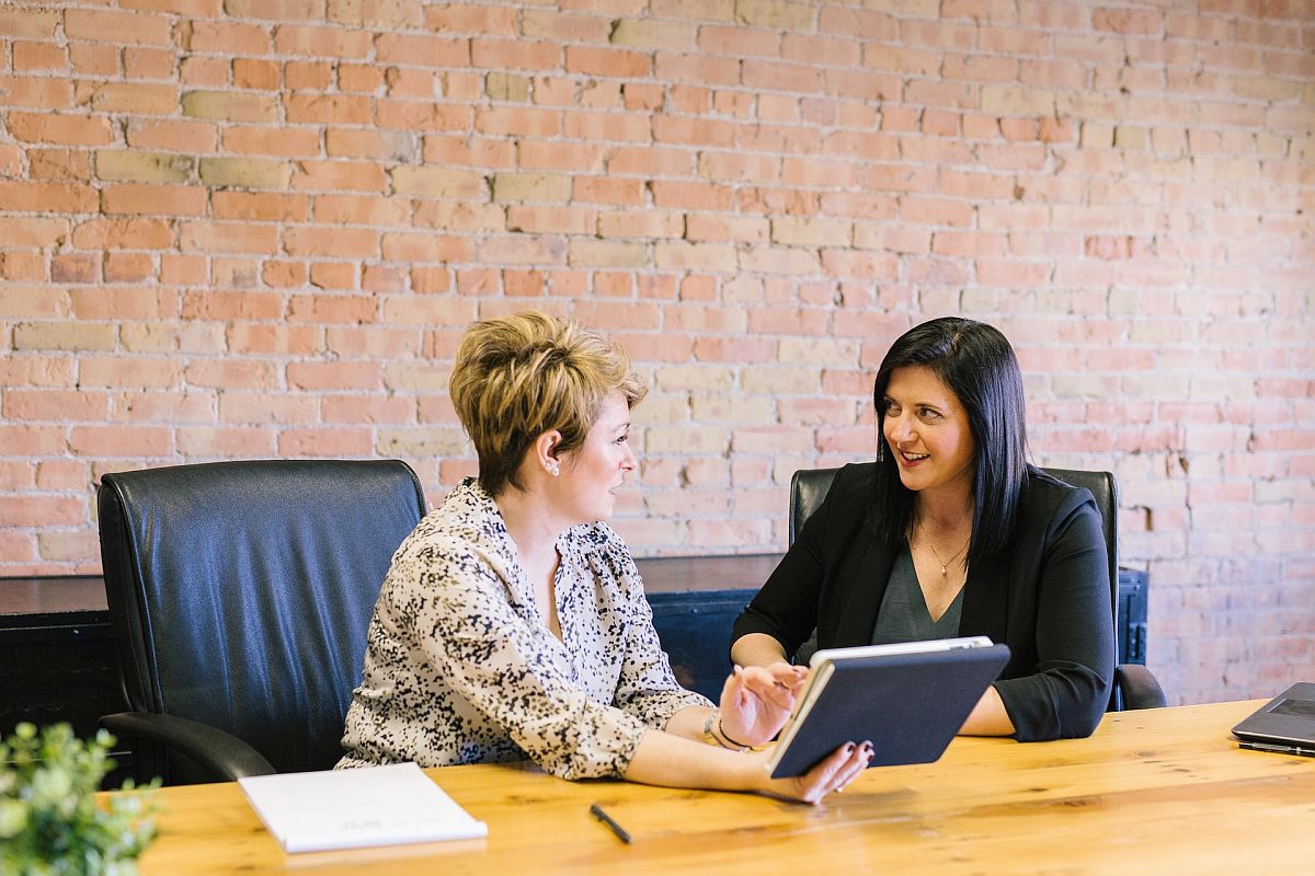 two coworkers chatting at a desk; publicizing reward personalization concept