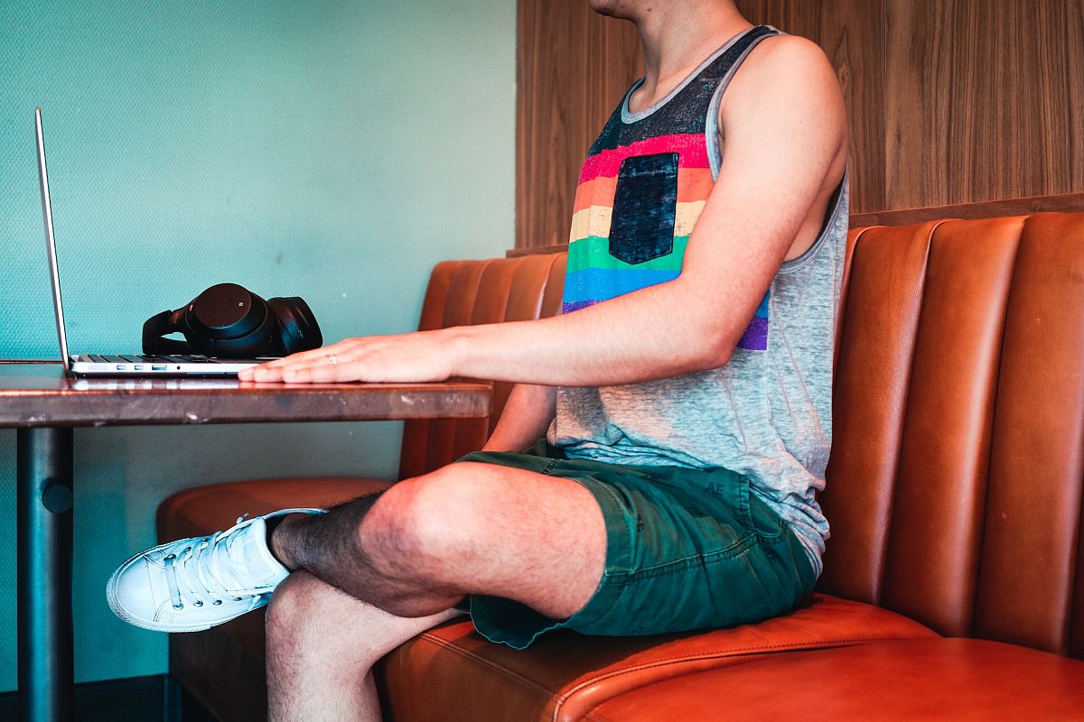 Young person sitting in a restaurant with a laptop; contingent workforce concept