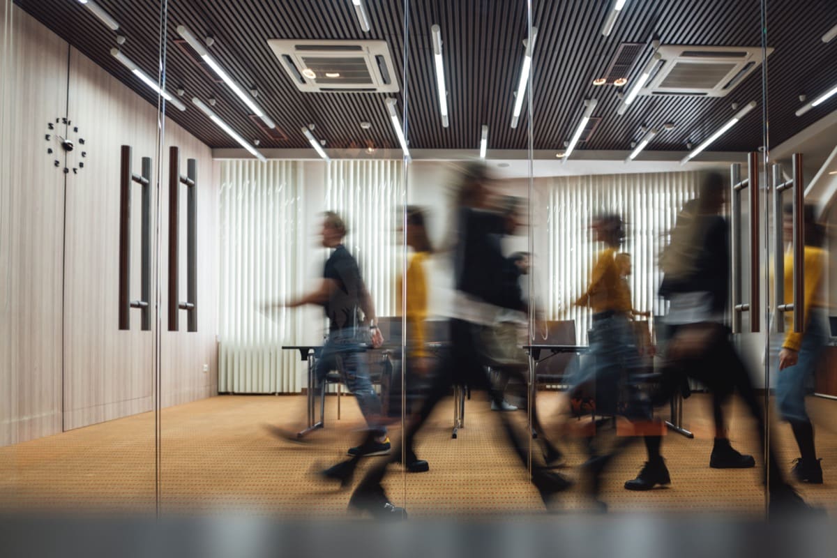 Group of office employees walking in blur; return to office concept