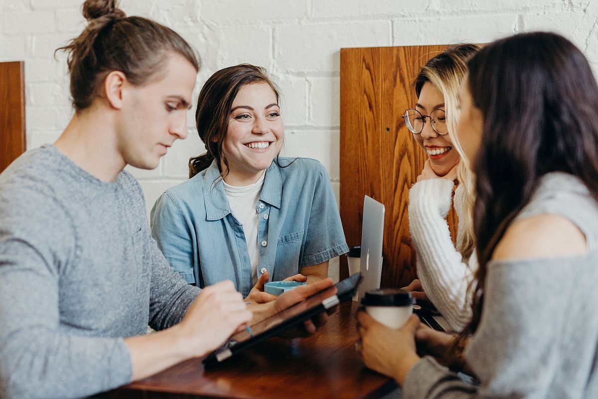 Group of smiling people at a table; employee recognition concept