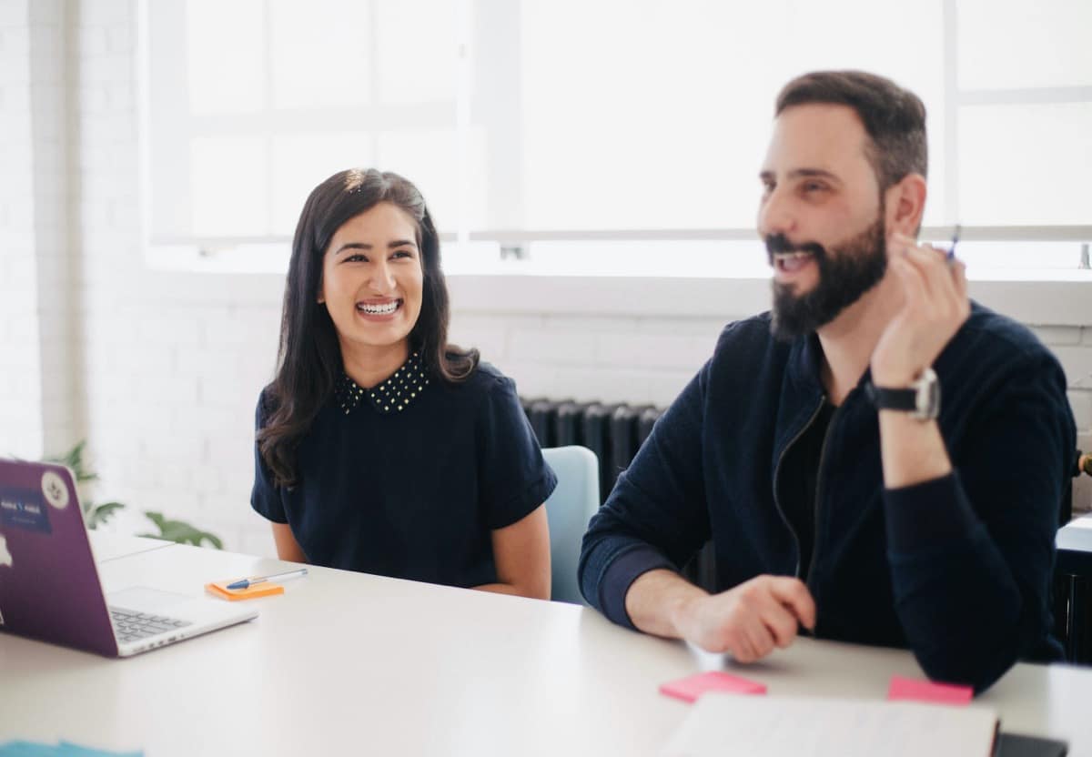 People smiling at professional meeting; DEI goals concept