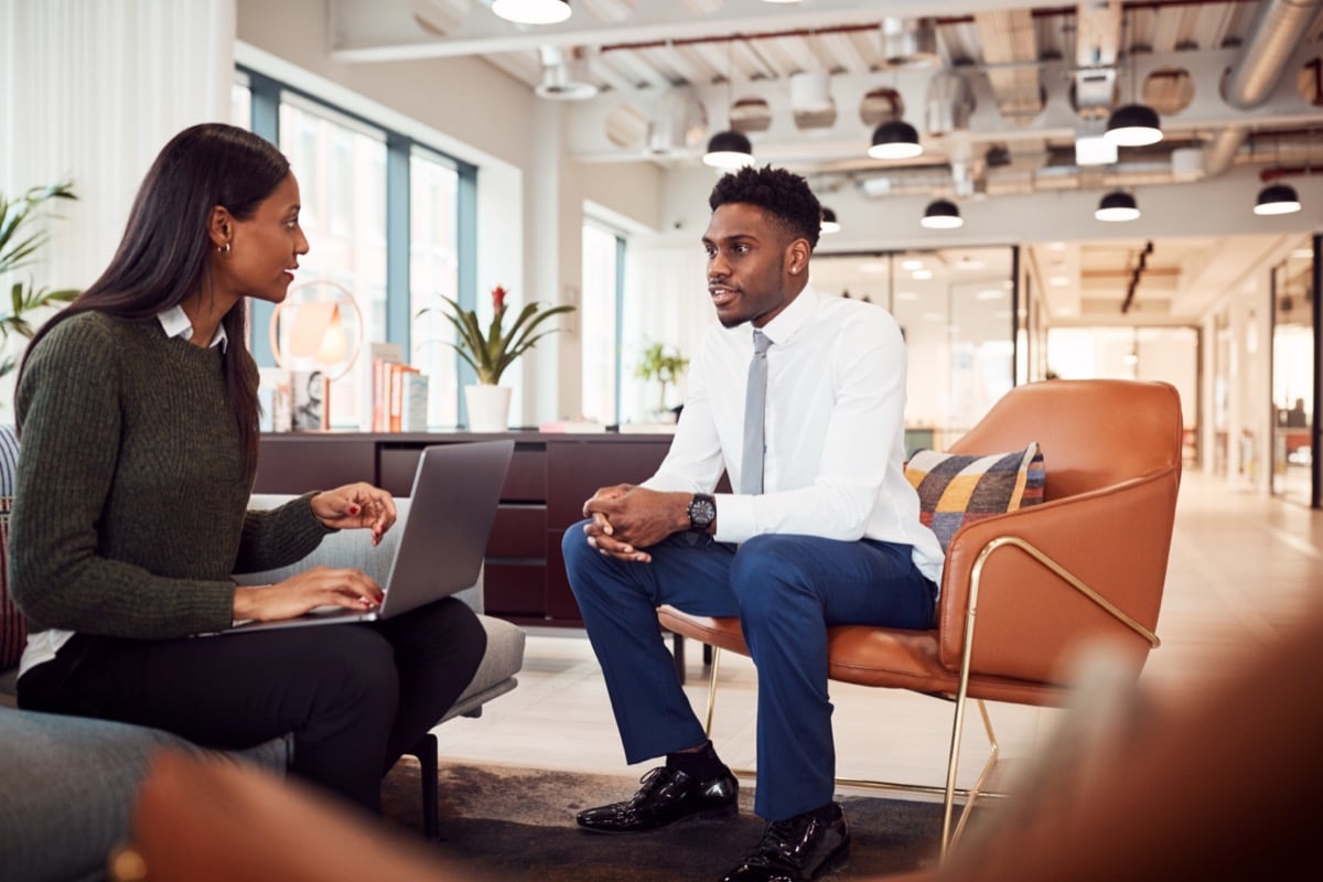 Businesswoman Interviewing Job Candidate In Seating Area Of Modern Office; Recruitment and Total Reward concept