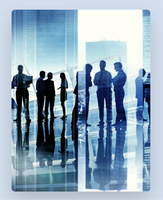 Businesspeople standing on reflective floor superimposed with skyscrapers