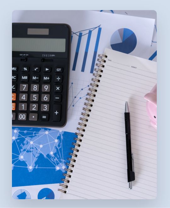 Aerial view of pen, notebook, calculator, and paper documents on desk